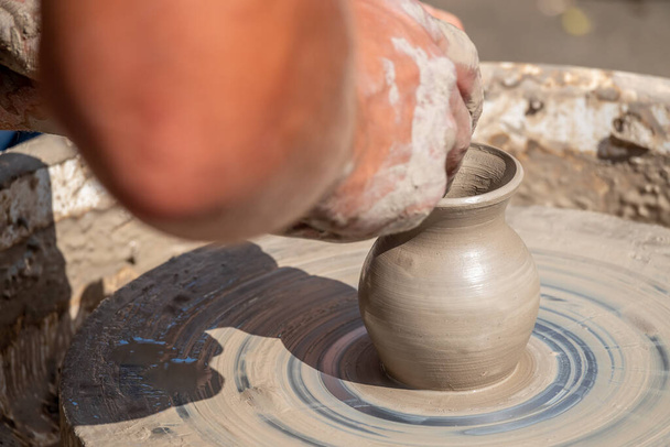 Un maestro ceramica fa una piccola, bella brocca su un disco rotante di argilla. Fatto a mano. Progettazione folcloristica locale. - Foto, immagini
