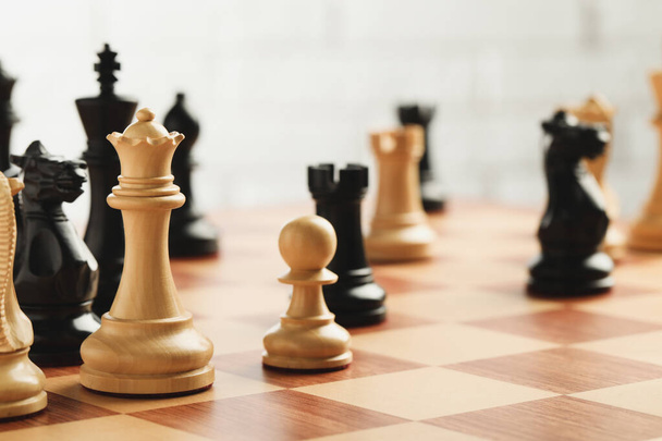 Chessboard with game pieces on light background - Zdjęcie, obraz