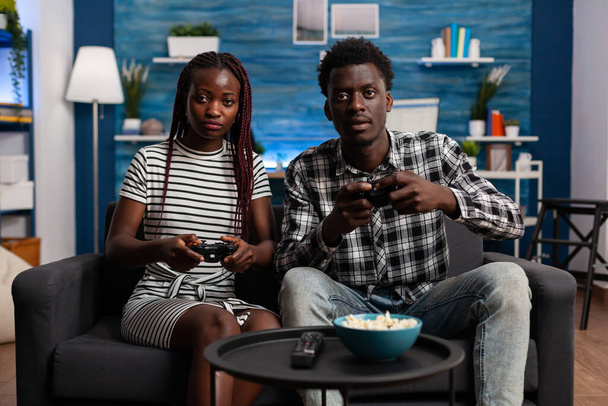 Αφροαμερικανό ζευγάρι που παίζει βιντεοπαιχνίδι στην τηλεοπτική κονσόλα - Φωτογραφία, εικόνα