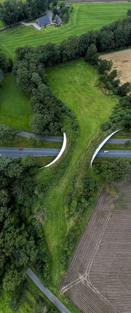 Long vertical aerial top down panorama of wildlife crossing over a freeway. Conservancy and preservation green corridor bridge for animals. Ecology an - Foto, Bild