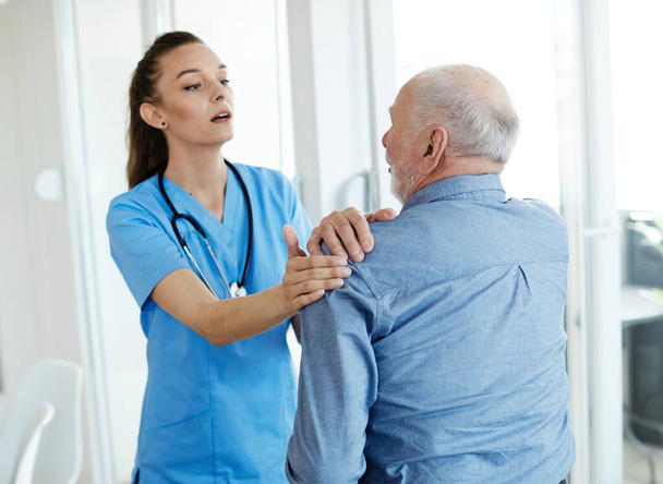nővér orvos idősgondozó segít asszisztencia nyugdíjas otthon fájdalom hátfájás váll - Fotó, kép