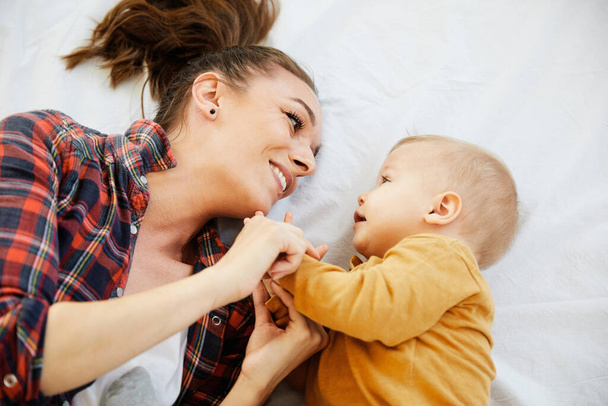 anya gyermek baba szórakozás család boldog gyermekkori ellátás vidám aranyos fiú nap - Fotó, kép