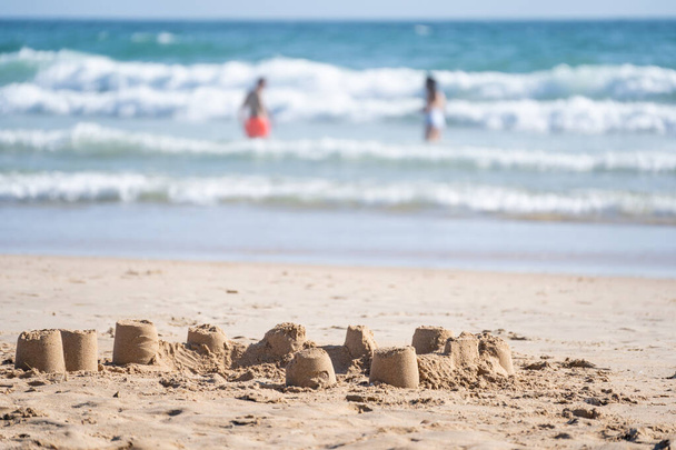 The small sand castles on the sandy beach on the coast - Foto, Imagem