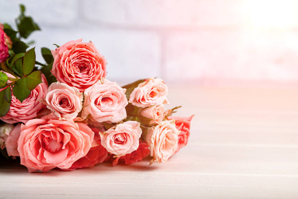Bouquet of pink roses on a light wooden background. Beautiful card. - Foto, Bild