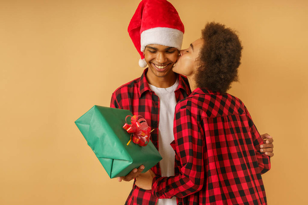 Счастливая и радостная афро-пара обмениваются подарками на Рождество - Фото, изображение