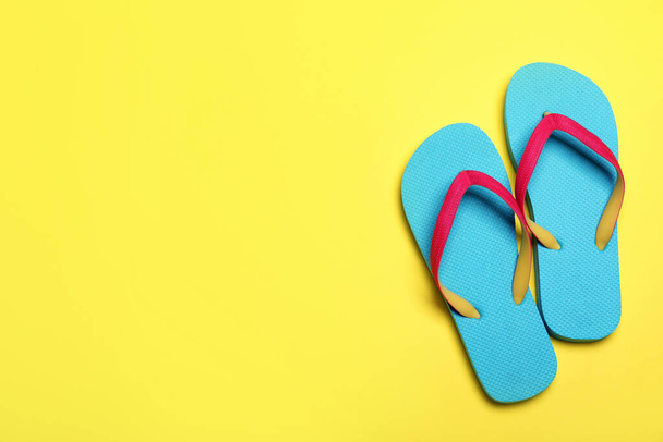Stylish flip flops on yellow background, flat lay. Space for text - Fotoğraf, Görsel