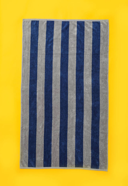 Striped beach towel on yellow background, top view - Valokuva, kuva
