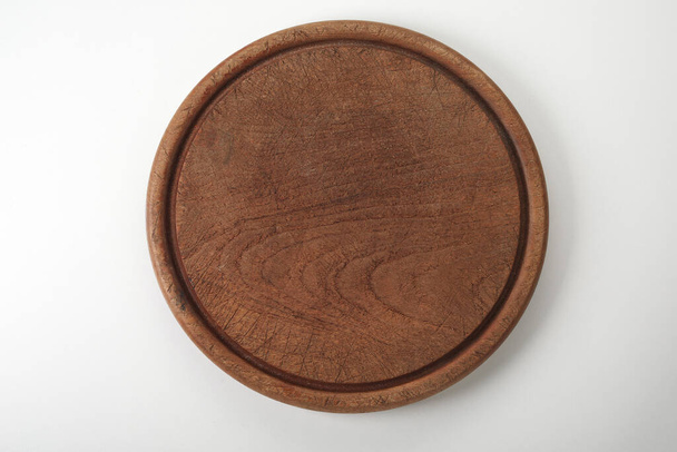 A top view of dark brown round wooden cutting board or tray  on white background - Foto, Bild