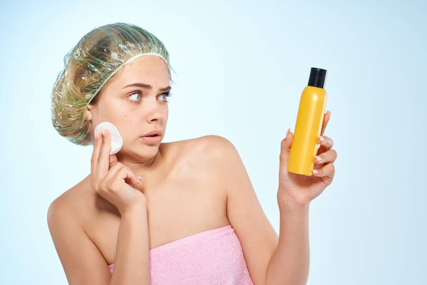 mujer limpia la cara con loción hombros desnudos cuidado de la piel cosmetología - Foto, Imagen