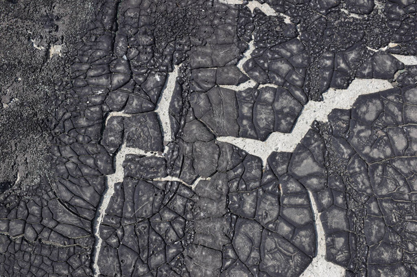Cracked old asphalt material. Applied to a concrete surface. Cracks in the resin are evidence of the times. - Photo, Image
