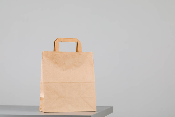 Bolsa de papel marrón con asas, bolsa de compras vacía con área para su logotipo o diseño, concepto de entrega de alimentos - Foto, imagen