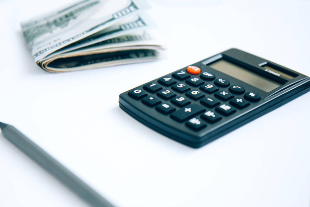 Калькулятор, паперові гроші ізольовані на білому тлі
 - Фото, зображення