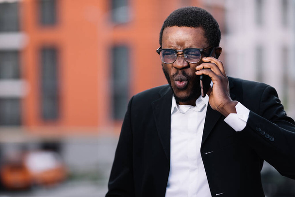 Afroamerikaner schreit laut ins Telefon. - Foto, Bild