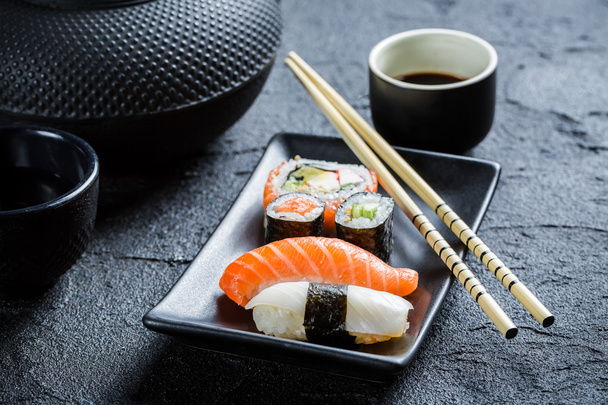 Closeup of fresh sushi served in a black ceramic - Photo, image