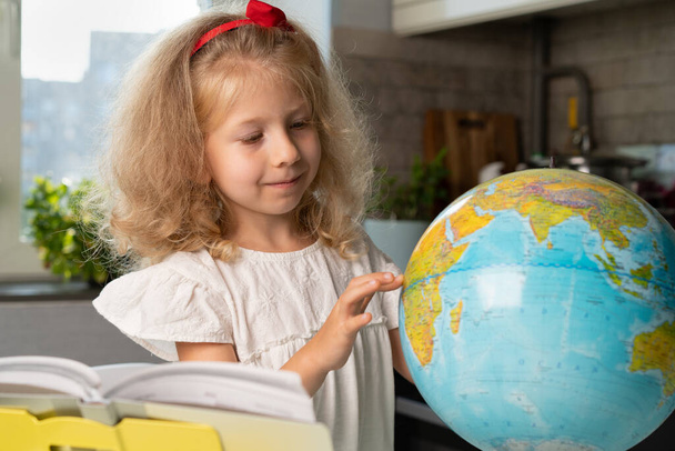 pieni tyttö, jolla on maapallo, opiskele maantiedettä, takaisin kouluun. - Valokuva, kuva