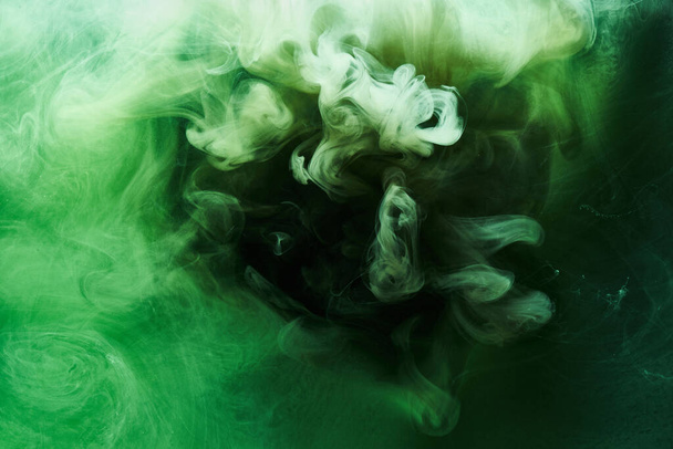 Abstract green color background. Swirling vibrant hookah smoke, underwater emerald ocean, dynamic paint in water - Photo, Image
