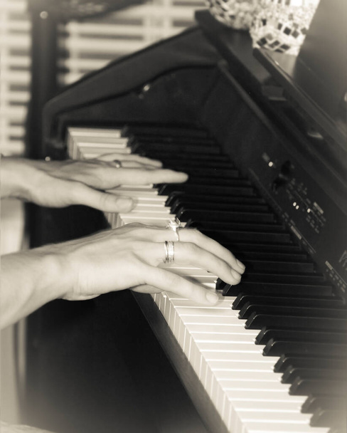 women's hands play on the piano keys - Фото, изображение