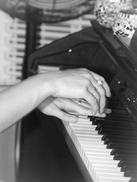 τα χέρια των γυναικών παίζουν με τα πλήκτρα του πιάνου - Φωτογραφία, εικόνα