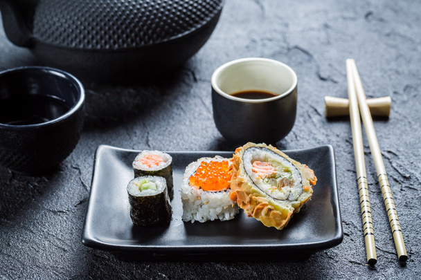 Sushi with soy sauce on the black ceramic dish - Photo, image