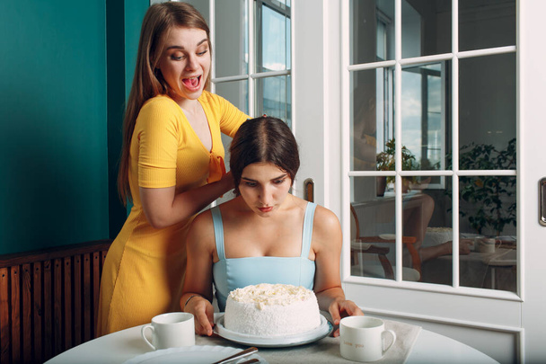 Genç kadın yüzünü kremalı pastaya daldırıyor. Mutlu yıllar.. - Fotoğraf, Görsel