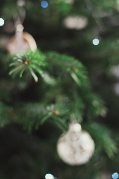 Θολή χριστουγεννιάτικο δέντρο και στολίδια φόντο. Πρωτοχρονιά και γιορτή των Χριστουγέννων - Φωτογραφία, εικόνα