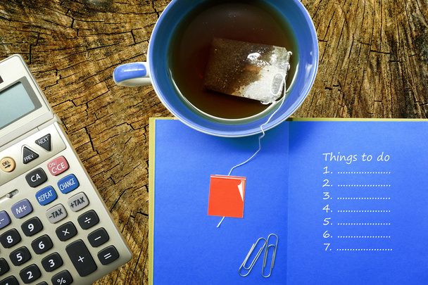 Papelería de oficina, calculadora, taza de café, cuaderno con cosas que hacer lista
 - Foto, imagen