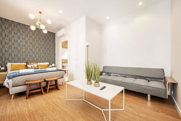 Nappali kanapéval és dohányzóasztallal, king suze bed and gold cushions in a vacation rental apartment - Fotó, kép