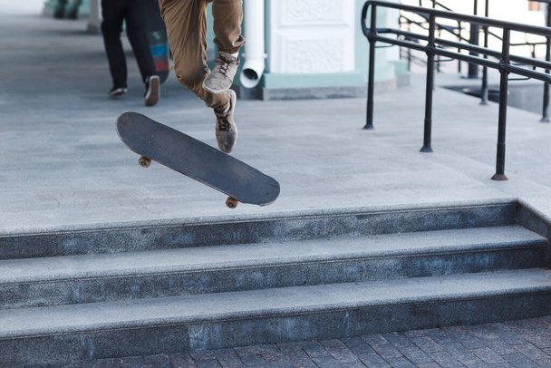 Jonge jongen rijden truc op skateboard in de stad - Foto, afbeelding