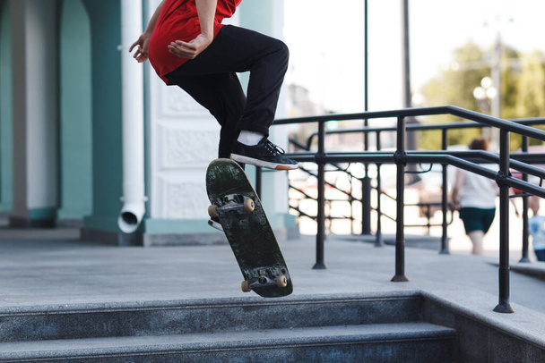Young boy riding trick on skateboard in city - Fotó, kép
