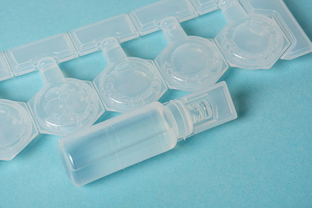 Plastic white container with medicine. Close-up on a blue background. - 写真・画像