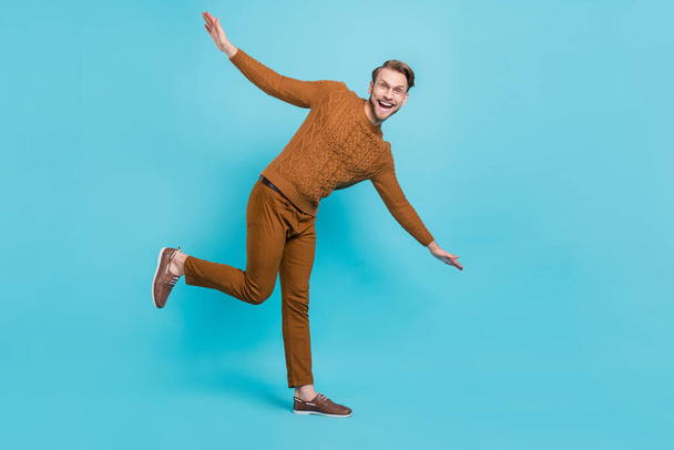Full body photo of charming happy young man dance hands wings smile isolated on blue color background - Fotoğraf, Görsel