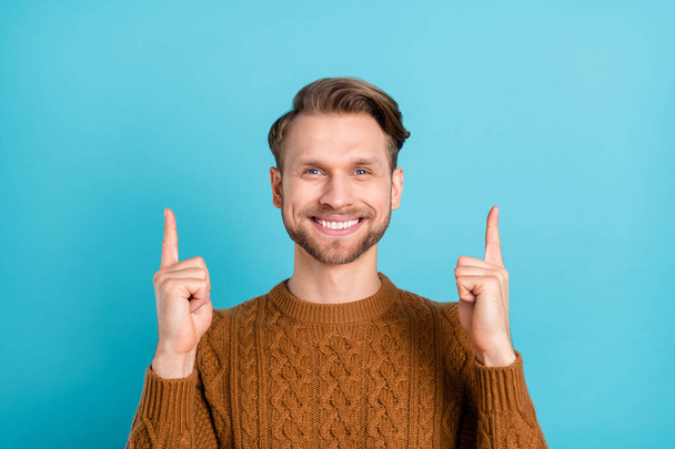 Foto de feliz atraente jovem apontar dedos até solução de venda de espaço vazio isolado no fundo de cor azul - Foto, Imagem