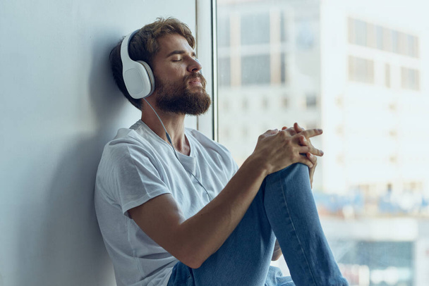 bearded man sitting in the room with headphones rest - Foto, Bild