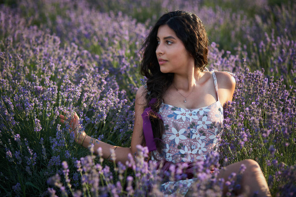Portrait of lovely brunette girl in lavender field. Summer lavender model posing in front of the camera. - Foto, Imagen