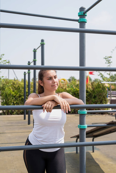 Gesunder und aktiver Lebensstil. Sport und Fitness. Glückliche Frau im weißen T-Shirt beim Training auf dem Sportplatz an einem sonnigen Sommertag - Foto, Bild