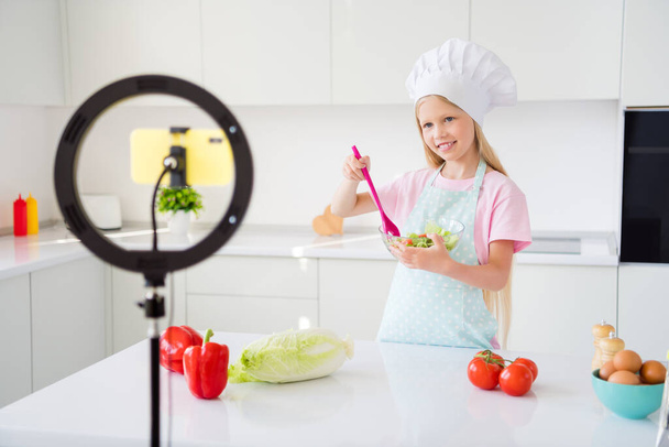 Photo of young girl happy positive smile cook salad vegetables ingredients lunch healthy food blogger make video indoors - Photo, Image