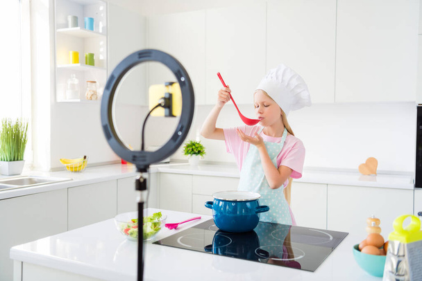 Profile side photo of young girl taste food meal cooking boil healthy supper video blogger lamp ring kitchen indoors - Fotó, kép