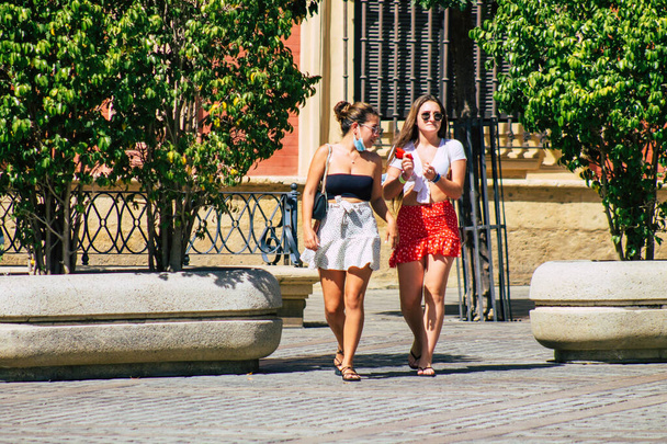 Σεβίλλη Ισπανία 21 Αυγούστου 2021 Οι τουρίστες που περπατούν στους δρόμους της Σεβίλλης κατά τη διάρκεια της επιδημίας του κορωναϊού χτυπώντας την Ισπανία, φορώντας μάσκα δεν είναι υποχρεωτικό αλλά οι περισσότεροι το φορούν. - Φωτογραφία, εικόνα