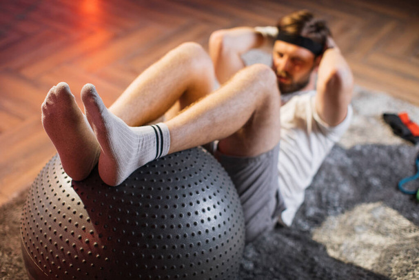 Handsome man doing exercises for abs on fitball at home - Zdjęcie, obraz
