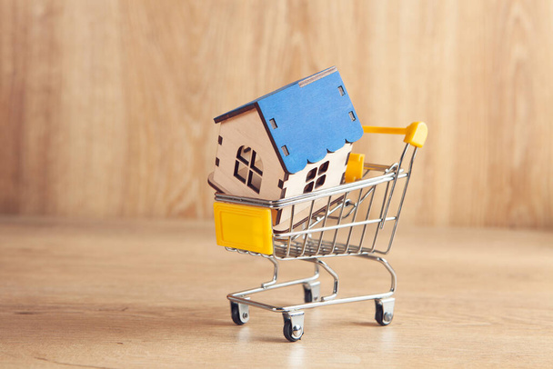 house in a basket. home purchase concept on wooden background: - Zdjęcie, obraz