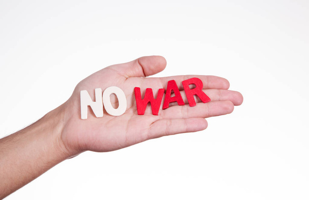 На руке деревянные письма с надписью "Нет войне" - Фото, изображение