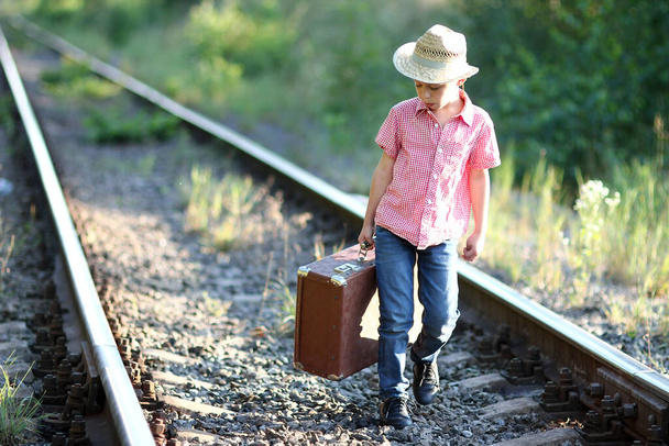 boy cowboy with suitcase and railroad western travel concept - Fotografie, Obrázek
