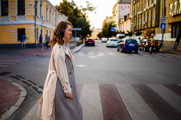 Μια γοητευτική νεαρή γυναίκα περπατάει στο δρόμο της πόλης. Ομορφιά, μόδα. - Φωτογραφία, εικόνα