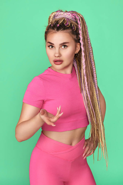 young woman with dreadlocks in pink sport wear - Photo, Image