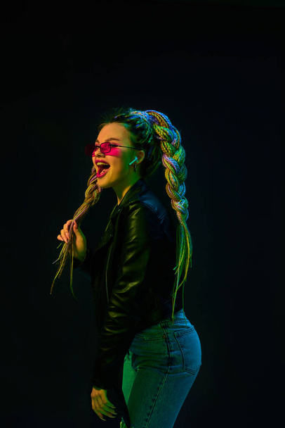 young woman with dreadlocks in red sunglasses dancing - Foto, afbeelding