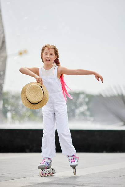 Cute little child girl on roller skates at park - Fotó, kép