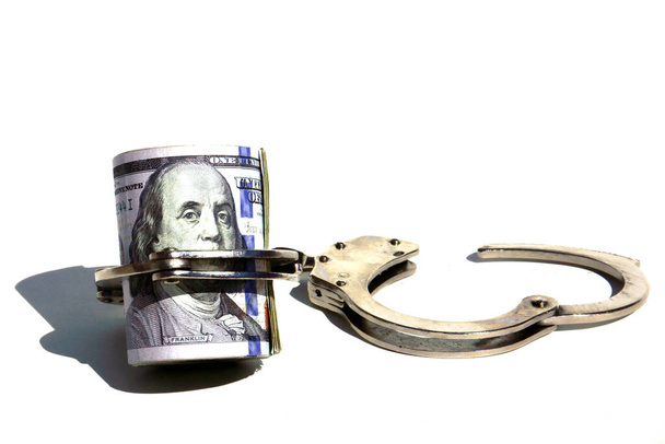 Money with Handcuffs. American Money Locked up with Hand Cuffs. Isolated on white. Room for text. Financial and Banking Concepts. Money or savings locked up for the future concepts. - Fotografie, Obrázek