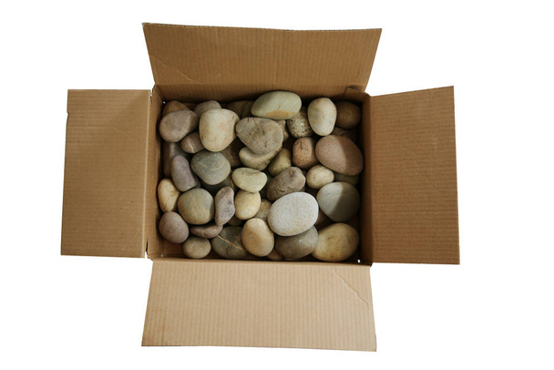 Box of Rocks. A cardboard box filled with rocks. Dumber than a Box of Rocks. Bad Boys and Girls get a Box of Rocks for Christmas. Isolated on white. Room for text. Round River Rocks in a Cardboard Box on a white background. Bad Christmas Gift. Stones - Photo, Image