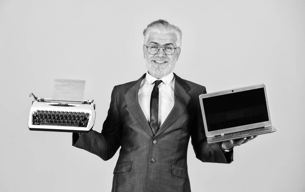 Distant Education. modern digital business. vintage typewriter. successful businessman retro typewriter and modern laptop. mature man dyed beard hair. computer or typewriter. new and old technology - Фото, изображение