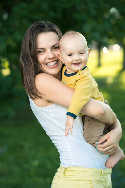 Happy mother holding a young son - Фото, изображение